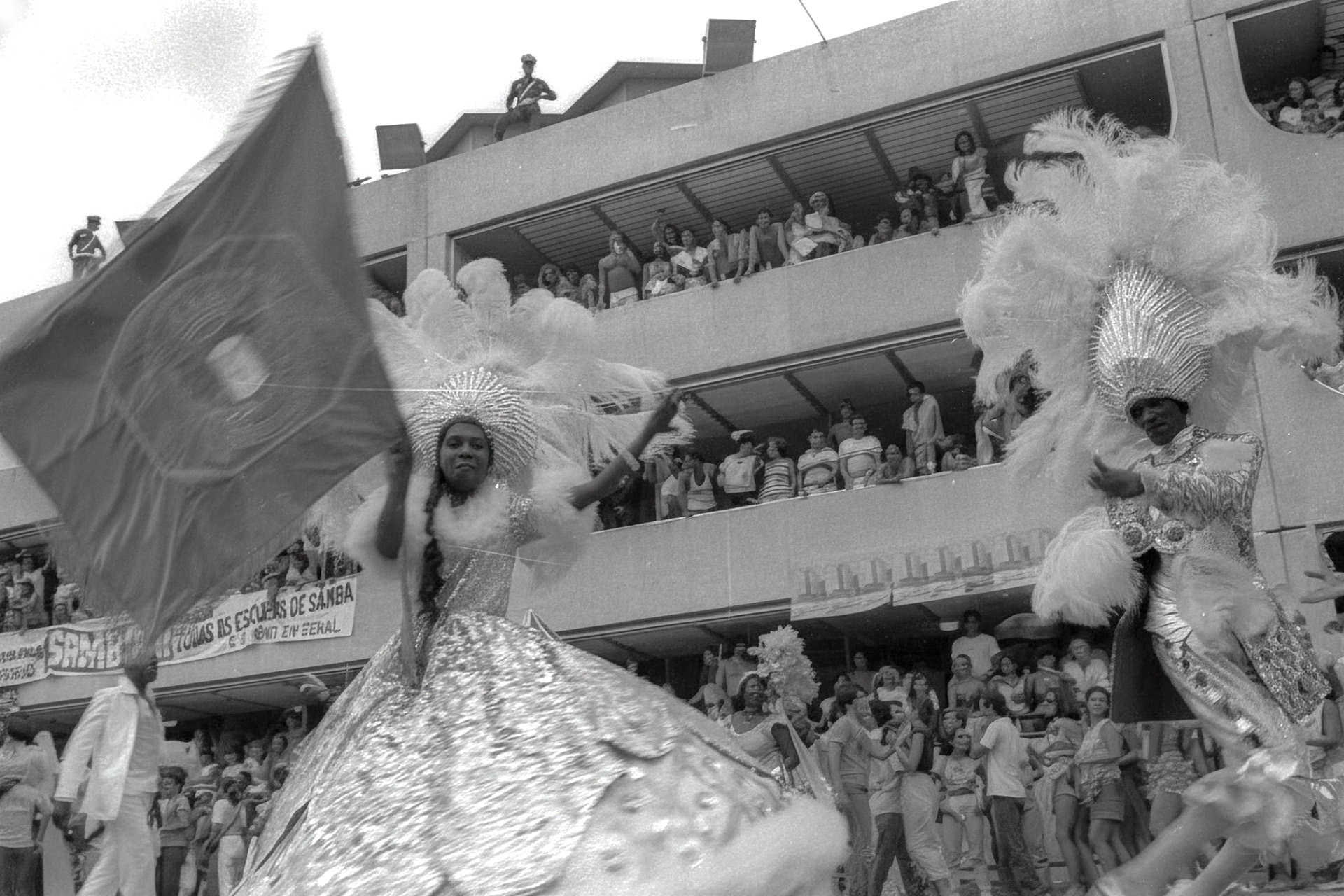 O mestre-sala Delegado e a porta-bandeira Mocinha desfilando pela Mangueira no Sambódromo com público ao fundo